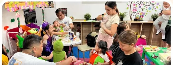 Children and parents at tables during a hands-on activity and snack time