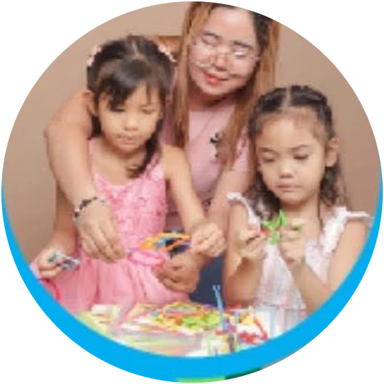 A teacher guiding two young girls through a hands-on activity