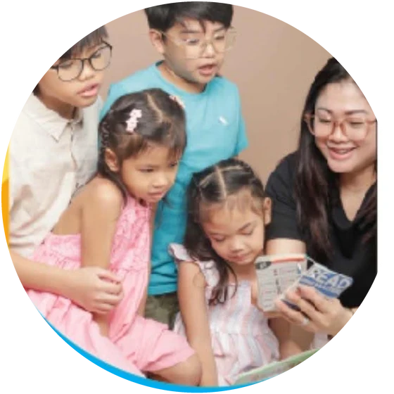 A teacher reading aloud with a group of attentive children